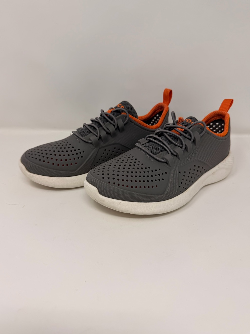 Crocs LiteRide Pacer sneakers in a charcoal, white, with orange accents. J1